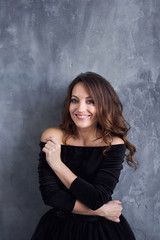 Fototapeta premium Beautiful girl with makeup and hairdo in a black dress
