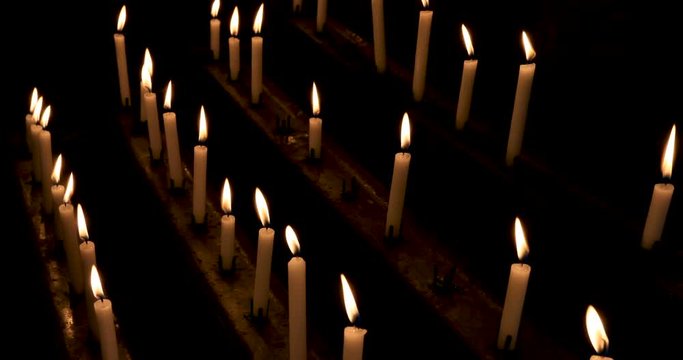 Prayer candles Carlisle Cathedral England dark room. The Cathedral Church of the Holy and Undivided Trinity. Cumbria, North West England. Augustinian priory. Ancient wood and stone work.