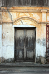 Fototapeta na wymiar Old wooden door in discolored concrete wall