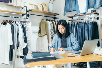 Business owner working at a laptop in clothing store
