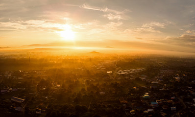 Aerial view of golden sunlight at sunrise with fog covered city town at the summer seasons.