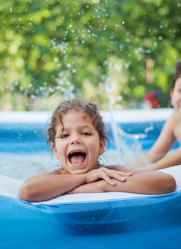 Happy child playing in an inflatable pool