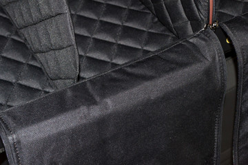 The inner part of the bag is a handmade organizer made of black and brown leather for a car trunk for storing things and tools in a shop window in a vehicle interior design workshop.