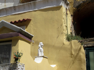 Dogville: house painted in a pastel yellow, with a sculpture of a white poodle