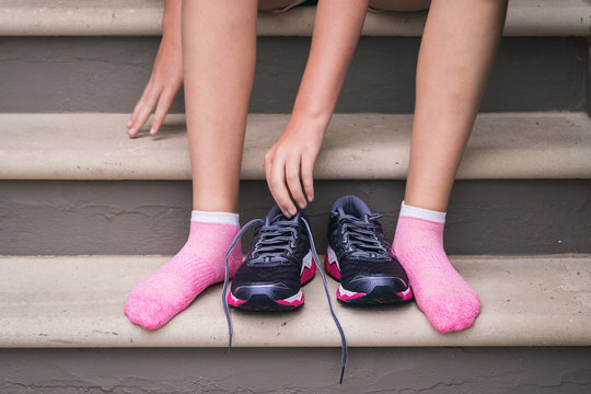 young woman putting on exercise shoes