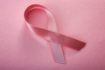 Breast cancer awareness concept with a pink silk ribbon isolated on pink background