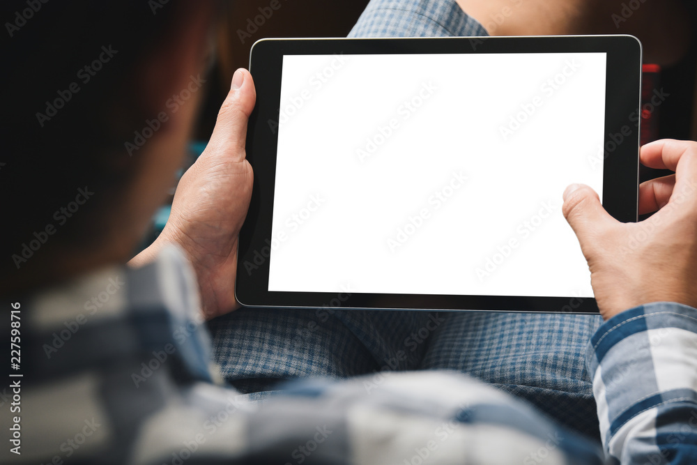 Poster Mockup tablet image, Man using tablet computer while sitting relax on chair with Clipping path on screen for easy replace you design mock up