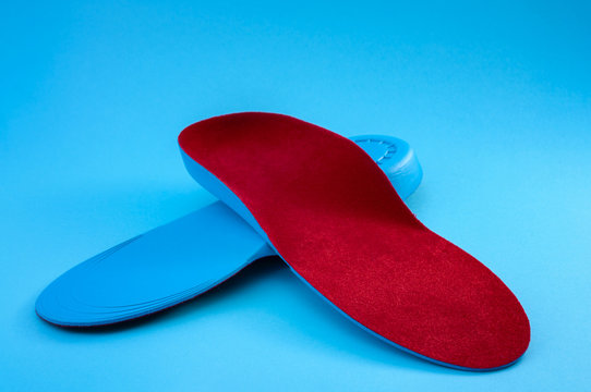 Foot Support And Healthy Feet Concept With Orthopedic Shoe Insoles Isolated On Blue Background