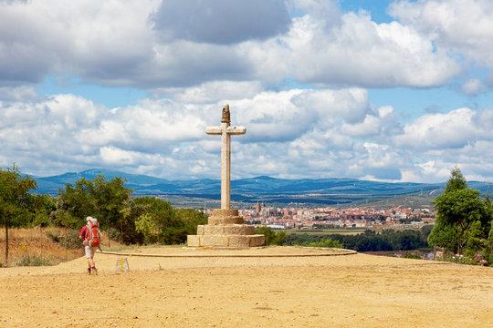 Camino de Santiago (Spain) - The Santo Toribio stone cross and a pilgrim walking along the way of St.James, near Astorga