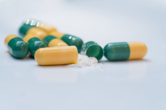 Pain killer capsules called "Tramadol HCL" with drug powder on white background.Tramadol HCL 50 mg