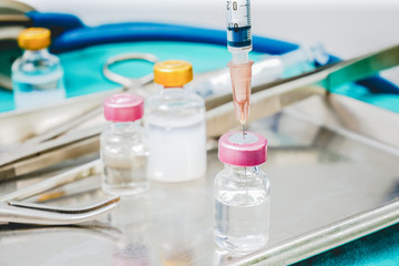 Syringe and medicine vials on doctor work park table close up for healthcare diagnosis concept background