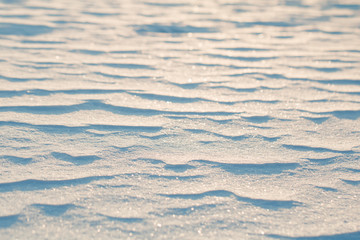 Close up view on frozen waves on a snow at sunset. Winter background.