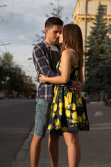 couple embracing against the background of the city, the road. urban romance.man stretches to the lips of a girl, wants to kiss her, attraction. sexuality