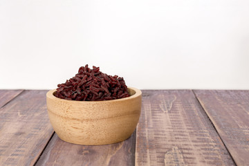 Wooden bowl with brown rice ready to eat. Deep Purple rice, Homnil rice.