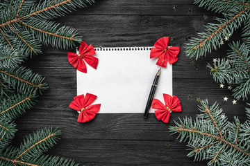 Letter for Santa Claus on black background, fir tree branches. Space for text, top view