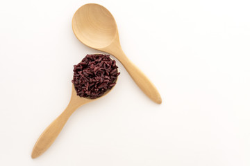 Wooden spoon with brown rice ready to eat. Deep Purple rice, Homnil rice.