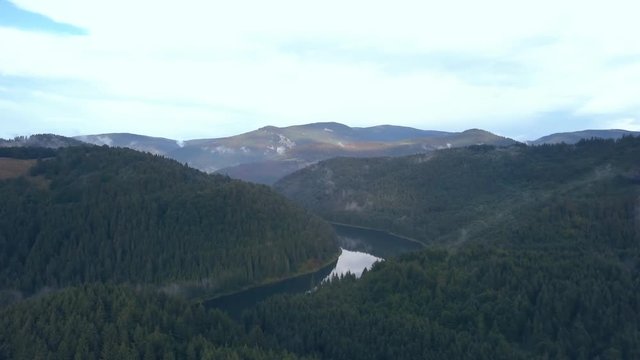 Aerial Footage Following a River through a Romanian Mountain Range then Panning to Reveal a Beautiful Landscape