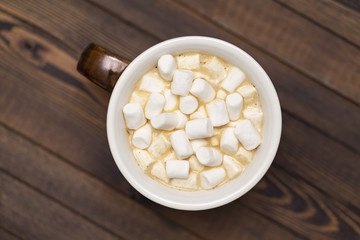 Cup of cocoa with marshmallows on wooden background, the view from the top
