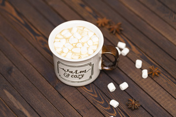 Cocoa with marshmallows on a wooden background in a Cup with the inscription 