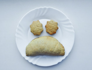 Cookies on a plate in the form of faces. Facial expression - sadness, disappointment