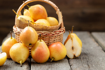 Fresh pears  in a basket on wooden table.