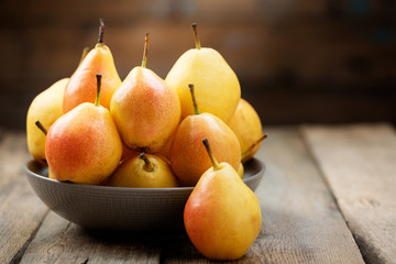 Pears. Pears harvest. Fresh organic pears in plate on wooden table. Pear autumn harvest. Autumn concept.