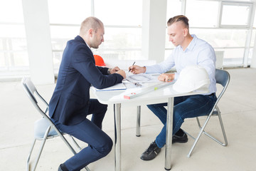 men engineers builders working at the table with a laptop, business negotiations at the...