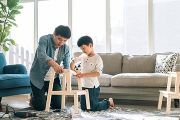 Father and son working on carpentry at home