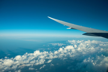 Fototapeta na wymiar Aircraft flying above the clound and blue sky.