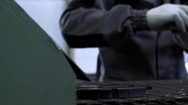 Worker At An Auto Parts Factory Removes Parts