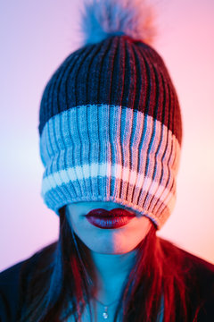 Anonymous woman with her head covered by a winter hat with only her red lips showing