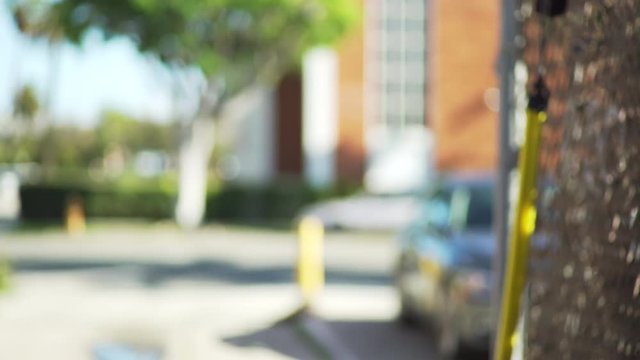 Defocused scene of an urban street with blurred cars and trees in daytime