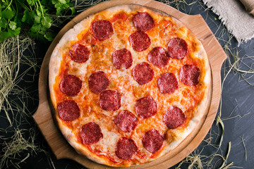 Pizza salami on wooden background