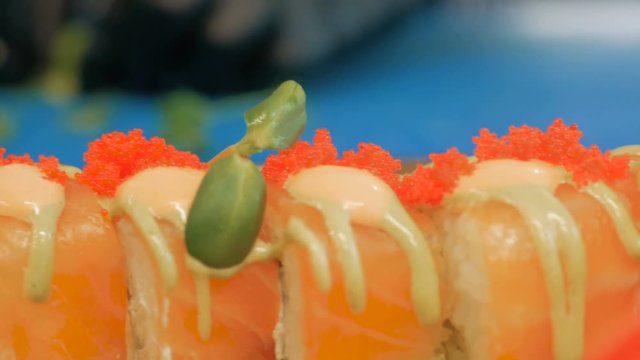 Close-up of professional chef's hands in black gloves making sushi and rolls in a restaurant kitchen. Japanese traditional food. Preparation process. step by step