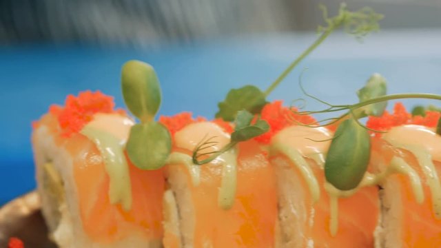 Close-up of professional chef's hands in black gloves making sushi and rolls in a restaurant kitchen. Japanese traditional food. Preparation process. step by step