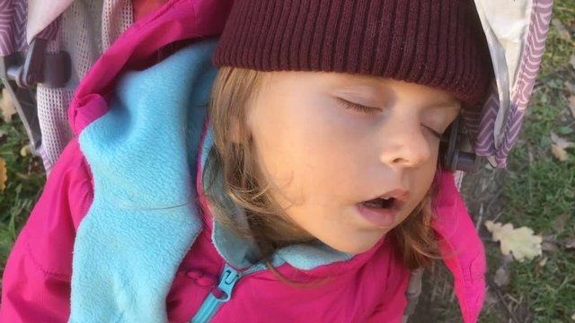 Toddler girl sleeping in stroller on a cold day, 4k slow motion video