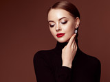 Beautiful Young Woman with Clean Fresh Skin. Perfect Makeup. Beauty Fashion. Red Lips. Cosmetic Eyeshadow. Smooth Hair. Girl in Black Turtleneck