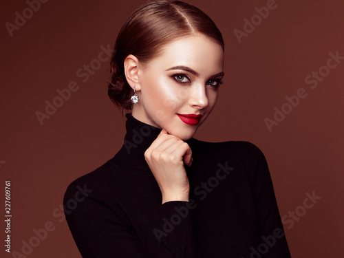 Beautiful Young Woman with Clean Fresh Skin. Perfect Makeup. Beauty Fashion. Red Lips. Cosmetic Eyeshadow. Smooth Hair. Girl in Black Turtleneck