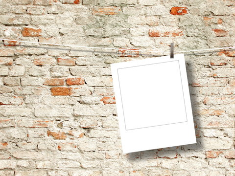 Blank square instant photo frame against old weathered brick wall background
