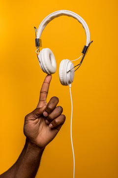 Concept shot of black man doing balance with white headphones