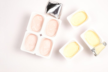 Plastic cup with tasty yogurt isolated on white. Top view. Space for text or design.