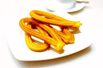 Churros on a plate on white background