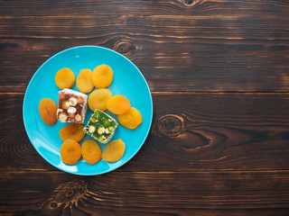 Natural Eastern sweets rahatlukum and dried apricots on a beautiful plate
