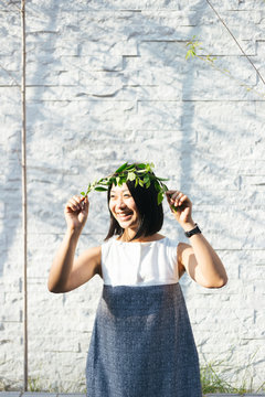 Portrait of smiling girl holding leaf crown