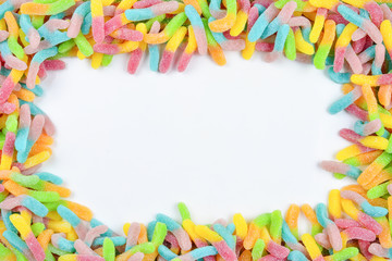 Frame of colorful gummy candies isolated on white. Top view. Space for text or design.