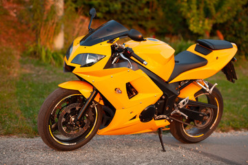 Yellow street motor bike parked on  edge of a road