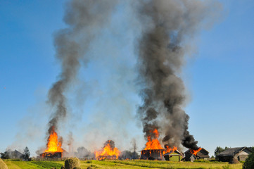Fototapeta na wymiar Burning village. The fire in the wooden house spread to the neighboring houses