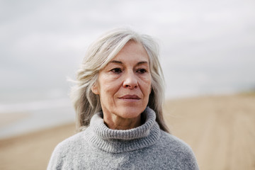 Fototapeta premium Senior woman on the beach in winter.