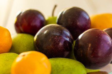 Detail of a fresh plums, mandarins and pears