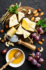Cheese with grape and nuts on wooden board